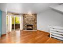 Bright living room featuring a cozy stone fireplace, hardwood floors, and a sliding glass door at 718 Julian Cir, Lafayette, CO 80026