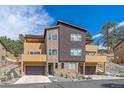 Modern exterior showcasing the architecture with stone and stucco, along with a two-car garage and landscaped entrance at 756 Dreamcatcher Ln, Evergreen, CO 80439