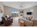 Comfortable living room with hardwood floors, fireplace, balcony, and large windows providing natural light and mountain views at 756 Dreamcatcher Ln, Evergreen, CO 80439