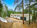Charming single-story home with a two-car garage and a gravel driveway at 28254 Tresine Dr, Evergreen, CO 80439