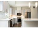Modern kitchen featuring stainless steel appliances, stylish gray cabinets, white countertops, and attractive lighting at 2858 W Parkside Pl, Denver, CO 80221