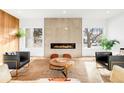 A modern living room featuring a fireplace, accent wall, stylish seating, and large windows at 1 S Forest St, Denver, CO 80246