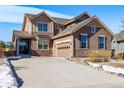 Beautiful two-story home with a two-car garage, stone accents, and a well-manicured lawn at 9335 Dunraven Loop, Arvada, CO 80007