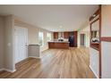 Open-concept kitchen featuring wood cabinets, stainless steel appliances, and wood laminate flooring at 11595 Pass Me By Rd, Strasburg, CO 80136