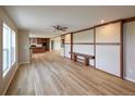 Spacious living room boasts wood laminate flooring, ceiling fan, large windows, and built-in bench at 11595 Pass Me By Rd, Strasburg, CO 80136