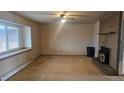 Cozy living room featuring a brick fireplace and large window for natural light at 2840 Wagner St, Strasburg, CO 80136