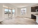Bright living area featuring hardwood floors, white walls, sliding glass doors to the outside, and modern trim at 635 Twilight St, Erie, CO 80516