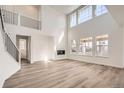 Spacious living room with high ceilings, large windows, hardwood floors, and a sleek fireplace feature at 635 Twilight St, Erie, CO 80516