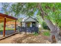 View of the house exterior showing a porch, yard, shed, and mature shade tree at 3429 Avenue D, Kittredge, CO 80457