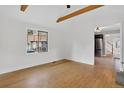 Bright living room featuring hardwood floors, exposed ceiling beams, and natural light at 3429 Avenue D, Kittredge, CO 80457