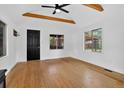 Living room with hardwood floors, exposed ceiling beams, and access to a front door at 3429 Avenue D, Kittredge, CO 80457