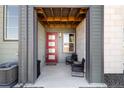 Inviting front entrance with a stylish red door and cozy seating area at 1525 W 68Th Ave, Denver, CO 80221