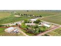 Aerial view outlines the property with its various buildings, road access, and neighboring agricultural land at 20995 County Road 28, Hudson, CO 80642