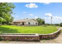 Large grassy backyard with a brick retaining wall, and a long wooden deck running along the back of the house at 20995 County Road 28, Hudson, CO 80642