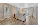 Bright living room with wood-look floors, neutral walls, and a decorative glass-accented front door at 3201 S Pearl St, Englewood, CO 80113