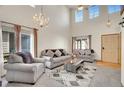 Spacious living room with tall ceilings, a ceiling fan, and ample natural light from multiple windows at 1214 S Akron Way, Denver, CO 80247