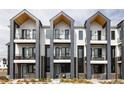 Contemporary townhouse featuring a stylish exterior with balconies and a mix of brick and siding, offering modern living at 8280 E 36Th Ave # 27, Denver, CO 80238