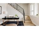 Bright home office area with modern black desk, stairs, and light wood floors for a functional workspace at 8280 E 36Th Ave # 27, Denver, CO 80238