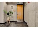 Hallway with neutral walls and modern touches, featuring a wooden door and mirror at 1020 15Th St # 210, Denver, CO 80202
