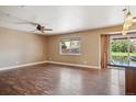 Spacious living room with hardwood floors, ceiling fan, and a sliding glass door to the backyard at 13895 W Atlantic Ave, Lakewood, CO 80228