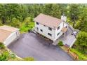 Aerial view of a home with a two-car garage, large driveway, and outdoor deck at 9189 Fallen Rock Rd, Conifer, CO 80433