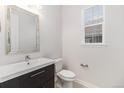 Clean half bathroom with modern vanity, stylish mirror, and neutral tile flooring at 3266 Yale Dr, Broomfield, CO 80023