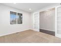 Bright office space with neutral carpet and trim, featuring a window and open French doors to another room at 3266 Yale Dr, Broomfield, CO 80023