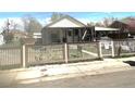 Charming single-Gathering home featuring a covered porch and a classic picket fence, with a carport on the right side at 4411 W Center Ave, Denver, CO 80219