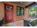 Inviting front porch with brick facade, black trim window, and a bright red door at 1010 Euclid Ave, Boulder, CO 80302