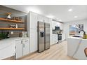 Modern kitchen with stainless steel appliances, white cabinetry, and open shelving at 3067 Robin Way, Denver, CO 80222