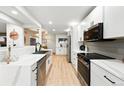 Bright, modern kitchen with white cabinets, stainless steel appliances, and sleek countertops at 3067 Robin Way, Denver, CO 80222