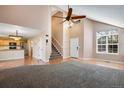 Bright living room featuring high ceilings, a fan, and large windows with a view at 12535 Forest View St, Broomfield, CO 80020