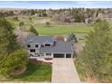 Beautiful two-story home with mature landscaping and a long driveway overlooking a golf course at 7575 E Windlawn Way, Parker, CO 80134
