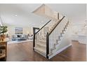 Inviting entryway with hardwood floors, staircase, and views into the living room and kitchen at 7575 E Windlawn Way, Parker, CO 80134