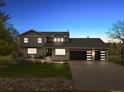 Charming two-story home with a three car garage, a seating area, and an illuminated walkway at 7575 E Windlawn Way, Parker, CO 80134