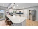 Modern kitchen with white cabinets, stainless steel appliances, and a large island at 362 Brigitte Dr, Northglenn, CO 80260