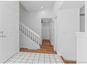 Bright entryway featuring tile and wood flooring, a staircase with white railing, and ample closet space at 3871 E Euclid Ave, Centennial, CO 80121
