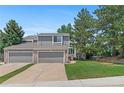 Charming two-story townhome with a well-manicured lawn, gray siding, brick accents, and an attached two-car garage at 3871 E Euclid Ave, Centennial, CO 80121