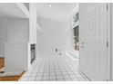 Bright living room with high ceilings, a fireplace, large windows, and tile floors leading to a spacious entry at 3871 E Euclid Ave, Centennial, CO 80121