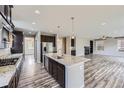 Open concept kitchen with granite countertops, stainless steel appliances, and hardwood floors at 11771 W Quarles Ave, Littleton, CO 80127