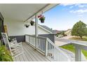 Cozy front porch with hanging flower baskets, white railing, and a place to relax at 1311 Fletcher Dr, Erie, CO 80516