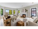 Bright living room with large windows, a fireplace, and neutral-toned furniture at 1311 Fletcher Dr, Erie, CO 80516