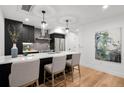 Contemporary kitchen featuring dark cabinets, stainless steel appliances, a center island, and stylish pendant lighting at 2451 Lawrence St # 2, Denver, CO 80205