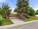 Street view of a single-Gathering home with a well-maintained lawn and mature trees at 8198 E Lehigh Dr, Denver, CO 80237