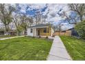 Charming house with well-maintained lawn and sidewalk leading to a cozy front porch at 4874 S Lincoln St, Englewood, CO 80113