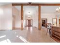 Spacious foyer featuring wood beams, tile flooring, and a view of the front door and adjacent rooms at 103 Red Wing Ct, Mead, CO 80542