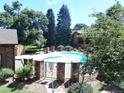 Community swimming pool surrounded by mature trees and a brick fence at 2215 S Buckley Rd # 201, Aurora, CO 80013