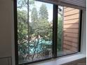 View of community pool and trees from interior window at 2215 S Buckley Rd # 201, Aurora, CO 80013