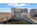 Charming two-story home boasts a front porch and two-car garage, set against a picturesque prairie backdrop at 4548 River Highlands Loop, Elizabeth, CO 80107