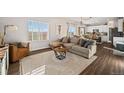 Open concept living room with natural light and wood laminate flooring at 4548 River Highlands Loop, Elizabeth, CO 80107